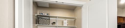 a laundry room with a washer and dryer and a closet with shelves