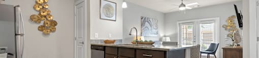 an open kitchen and living room with an island and a dining room table
