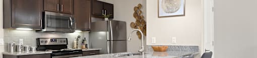 an open kitchen with a marble counter top and stainless steel appliances