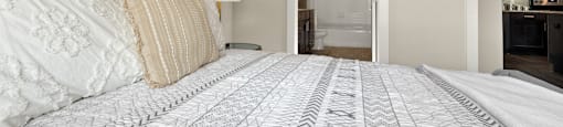 a bedroom with a large bed and a door to a bathroom