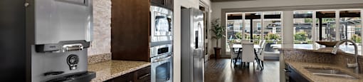 a large kitchen with stainless steel appliances and granite counter tops