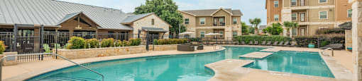 a swimming pool with an apartment building in the background