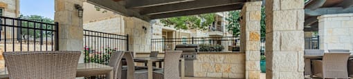a covered patio with tables and chairs