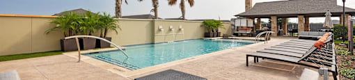 a swimming pool with lounge chairs and palm trees