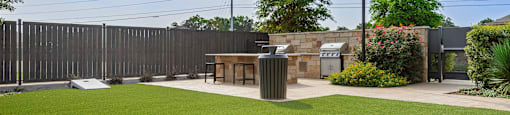 a lawn with a table and a barbecue grill in a backyard
