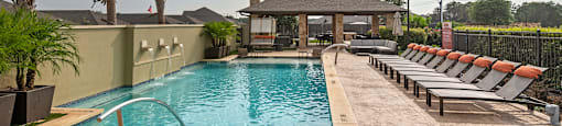 a swimming pool with chairs and a house in the background