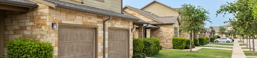 a house with two garages and a sidewalk in front of it