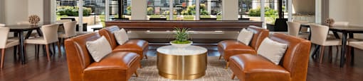 a lounge area with leather chairs and a coffee table