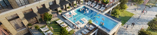 A large outdoor swimming pool surrounded by lounge chairs and umbrellas.