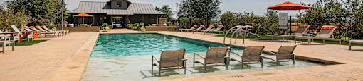 a pool with chairs and a building in the background