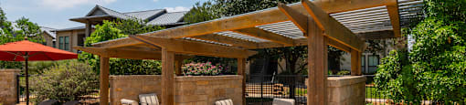 a patio with a pergola and patio furniture