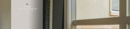 a room with a window and a table with a lamp
