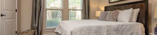 a bedroom with a bed and two windows