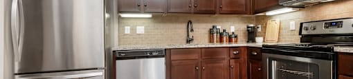 a kitchen with dark wood cabinets and stainless steel appliances