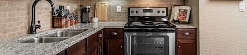 a kitchen with dark wood cabinets and stainless steel appliances
