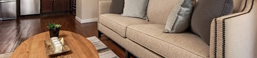 a living room with a couch table and a kitchen in the background