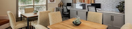 a dining area with a wooden table and chairs and a kitchenette with a countertop and
