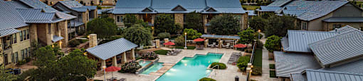 an aerial view of the resort style pool with lounge chairs and umbrellas