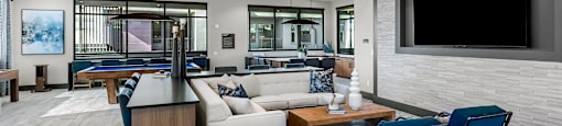 A modern living room with a pool table and a television.