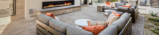 A patio with a fireplace and seating area.