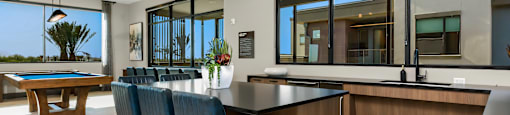 A modern kitchen with a pool table and bar area.