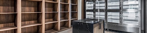 A room with a black counter and wooden shelves.