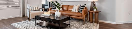 A living room with a brown leather couch and a coffee table.