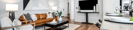 A modern living room with a brown sofa and a black chair.