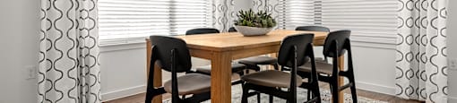 A dining room with a table and chairs.