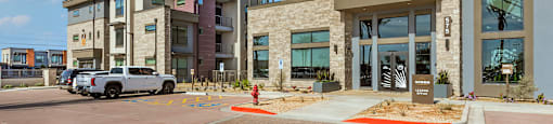 A modern building with a parking lot in front.