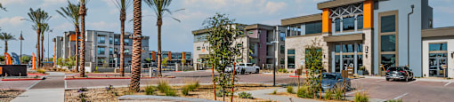 A modern building complex with palm trees in front.