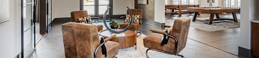 a living room with chairs and a table