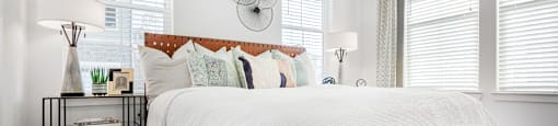 a bedroom with a bed and three windows