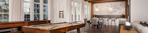 a large living room with a pool table and a dining room