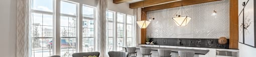a dining area with a round table and chairs and a kitchen with a large window