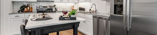 a kitchen with stainless steel appliances and a marble counter top