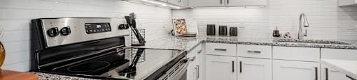 an updated kitchen with white cabinets and granite counter tops