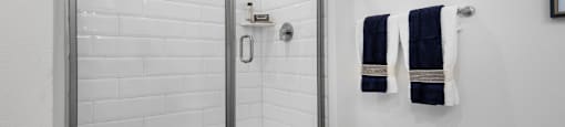 a shower with a glass door in a white bathroom