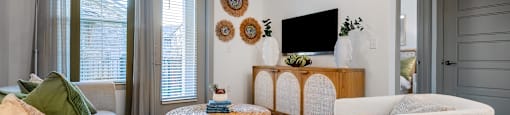 a living room with two white chairs and a tv