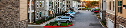 a row of town houses with cars parked in a street