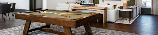 a living room with a pool table and a tv