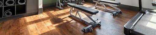 a gym with weights and a tv on the wall