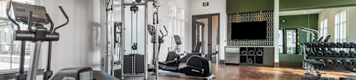 a gym with weights and other exercise equipment and a tv