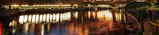 a city at night with a river and buildings