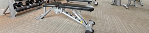 a spacious fitness center with cardio equipment and weights