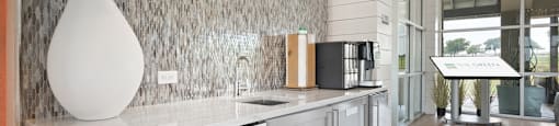 a kitchen with white cabinets and a white vase with a plant in it