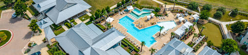 arial view of a resort style pool surrounded by gray roofs