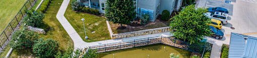 an aerial view of the koi pond and patio at the whispering winds apartments in pearland