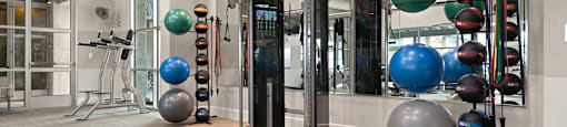 a spacious fitness room with exercise equipment and large exercise balls