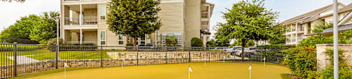 a putting green with a building in the background